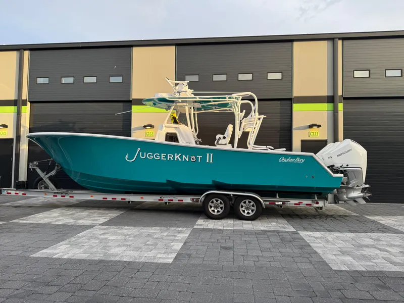 Slide: The Image of 2020 Onslow Bay 33 Tournament boat on trailer, parked outside a garage. - 60