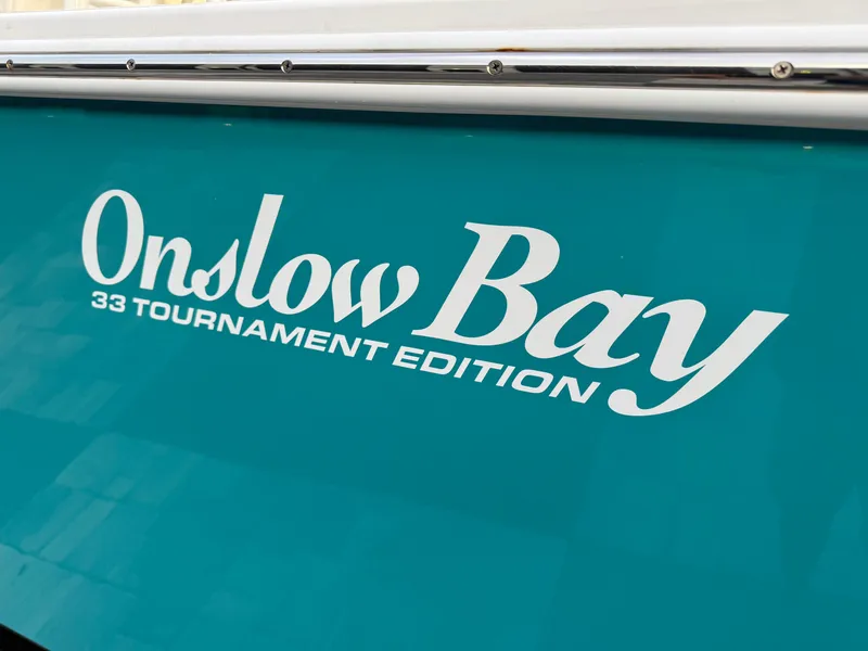 Slide: The Image of 2020 Onslow Bay 33 Tournament Edition boat logo on teal background. - 63