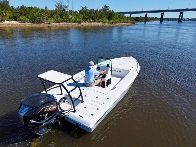 Slide: The Image of 2025 Action Craft 20 Flats boat cruising on a river near a bridge. - 16