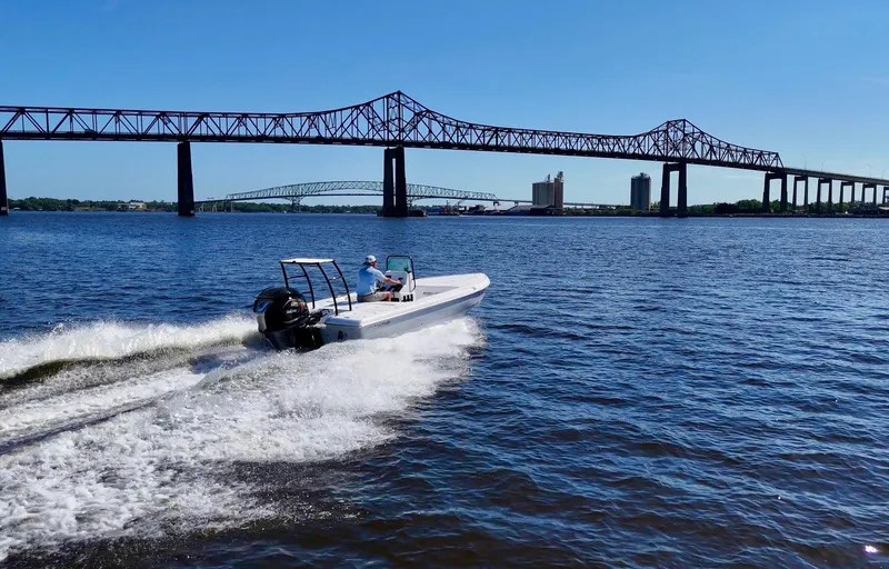 Slide: The Image of 2025 Action Craft 20 Flats boat cruising under a bridge on a sunny day. - 23