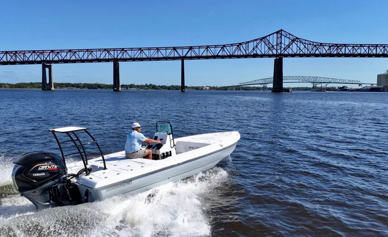 Slide: The Image of 2025 Action Craft 20 Flats boat cruising under a bridge on a sunny day. - 24
