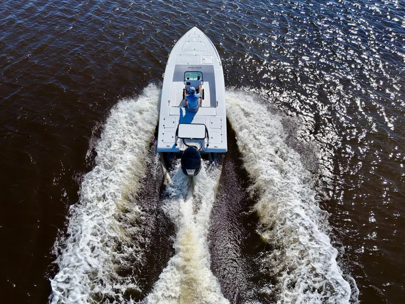 Slide: The Image of 2025 Action Craft 20 Flats boat cruising on open water, viewed from above. - 6