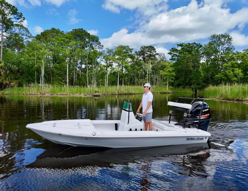 Slide: The Image of 2025 Action Craft 17 Flats boat on calm water, surrounded by lush greenery. - 24
