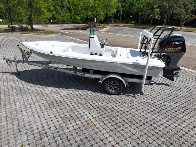 Slide: The Image of 2025 Action Craft 17 Flats boat on trailer, parked outdoors with Yamaha outboard motor. - 28