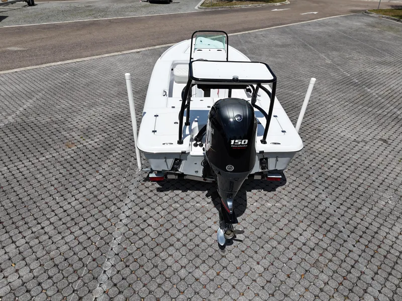 Slide: The Image of 2025 Action Craft 17 Flats boat with 150 HP outboard motor, parked on paved surface. - 39
