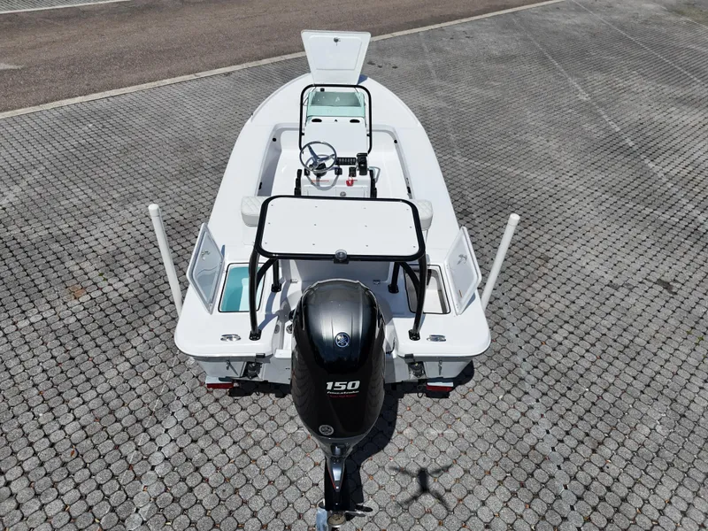 Slide: The Image of 2025 Action Craft 17 Flats boat with 150 HP engine, parked on a paved surface. - 59