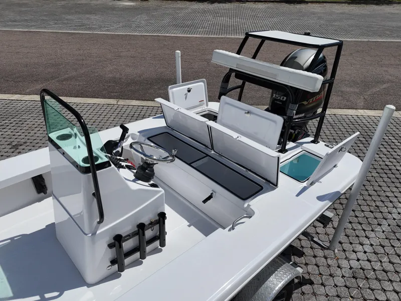 Slide: The Image of 2025 Action Craft 17 Flats boat with open storage compartments and motor, displayed on a trailer. - 63
