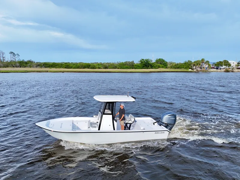 The Image of 2025 Action Craft 24 Coastal Bay boat cruising on a scenic waterway. - 0