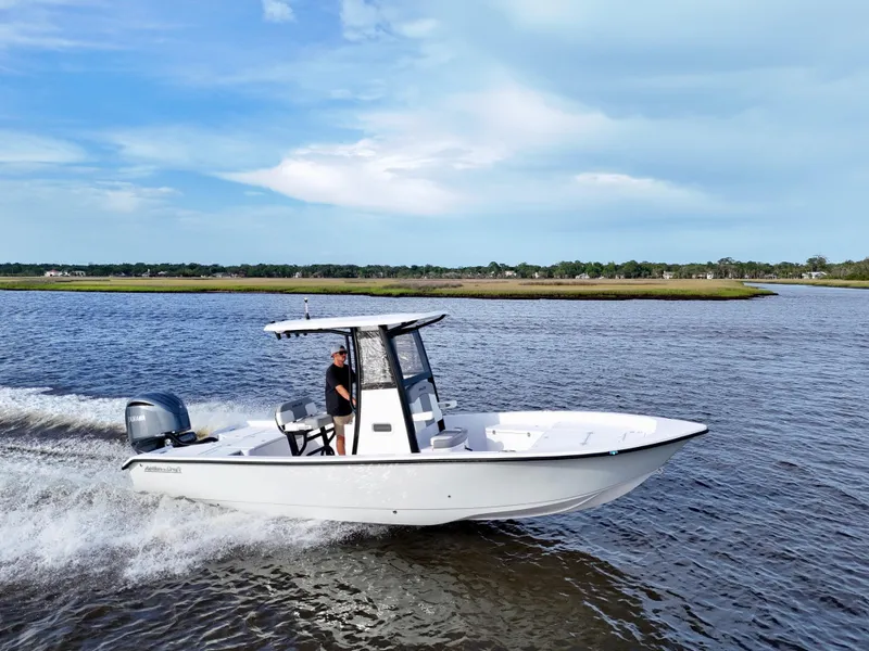 Slide: The Image of 2025 Action Craft 24 Coastal Bay boat cruising on a scenic waterway. - 1