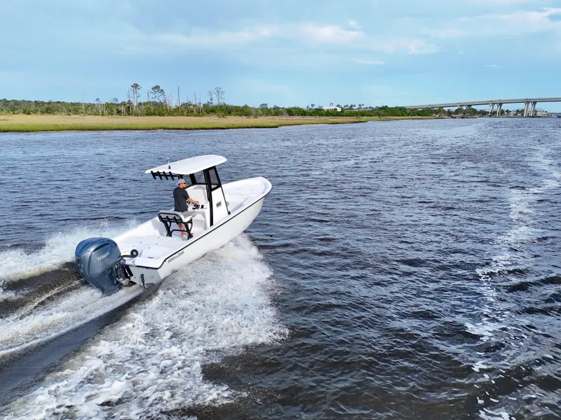 Slide: The Image of 2025 Action Craft 24 Coastal Bay boat cruising on a scenic river. - 18