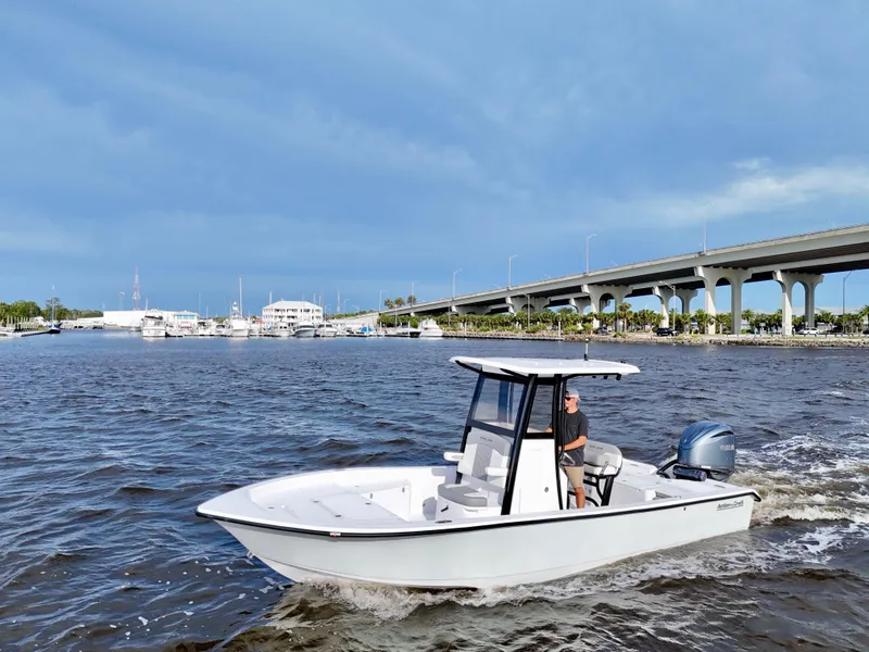 Slide: The Image of 2025 Action Craft 24 Coastal Bay boat cruising near a bridge on a sunny day. - 20
