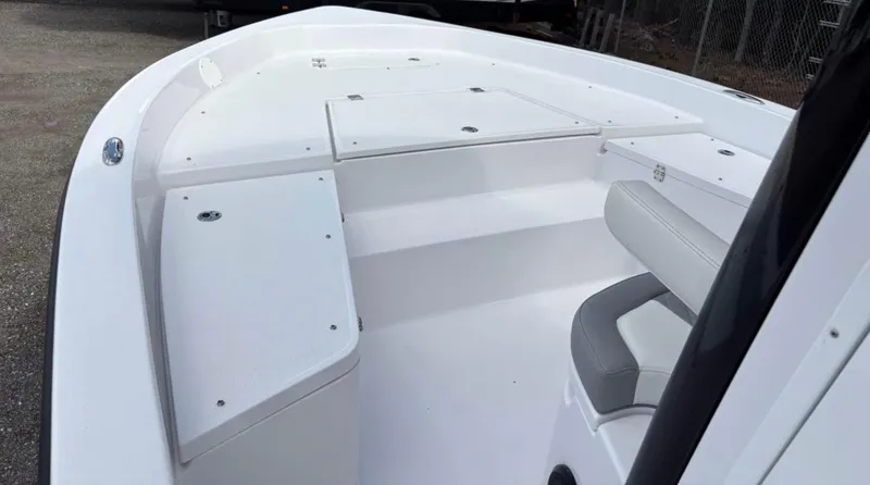 Slide: The Image of 2025 Action Craft 24 Coastal Bay boat interior with white seating and storage compartments. - 28