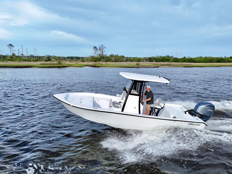 Slide: The Image of 2025 Action Craft 24 Coastal Bay boat cruising on a scenic waterway. - 5