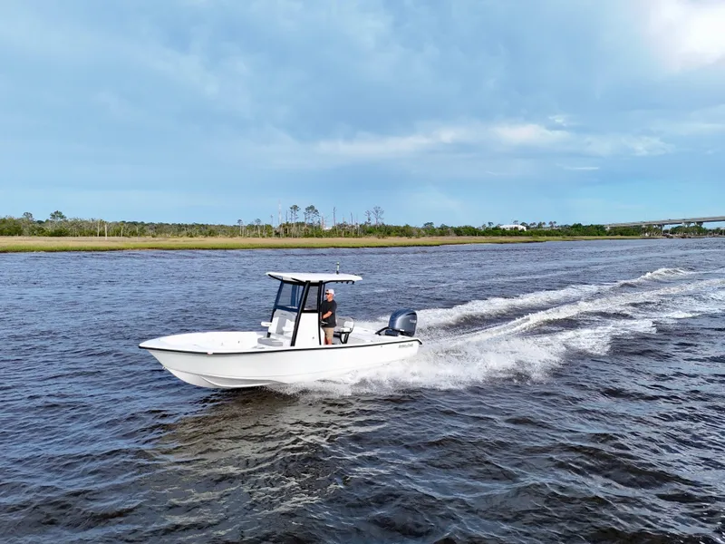 Slide: The Image of 2025 Action Craft 24 Coastal Bay boat cruising on a scenic waterway. - 7