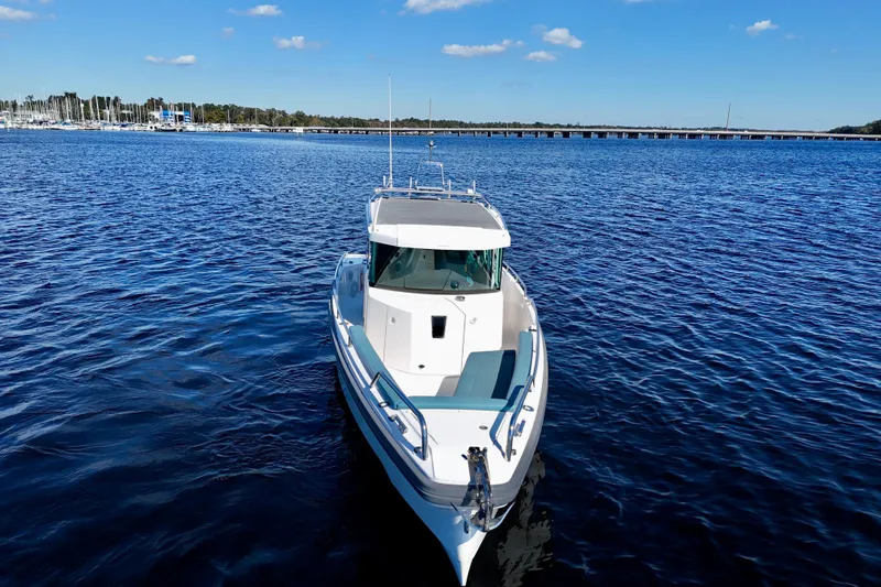 Slide: The Image of 2020 Axopar 28 CABIN boat on calm blue water under clear sky. - 14
