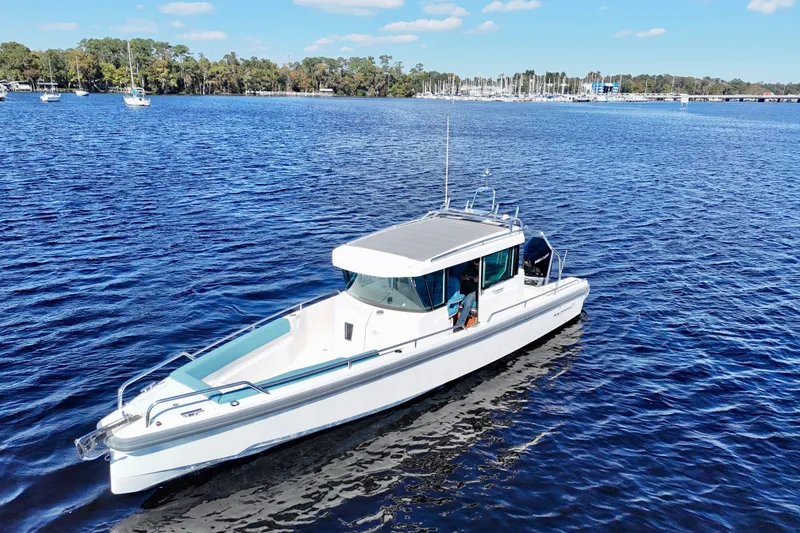 Slide: The Image of 2020 Axopar 28 CABIN boat cruising on a serene blue lake. - 17