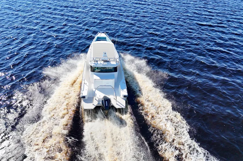 Slide: The Image of 2020 Axopar 28 CABIN boat cruising on open water, aerial view. - 2