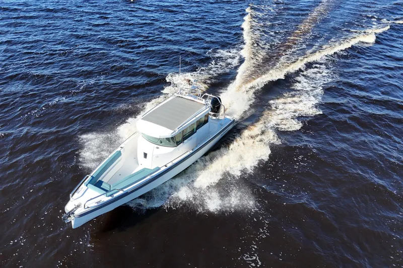 Slide: The Image of 2020 Axopar 28 CABIN boat cruising on open water, aerial view. - 36