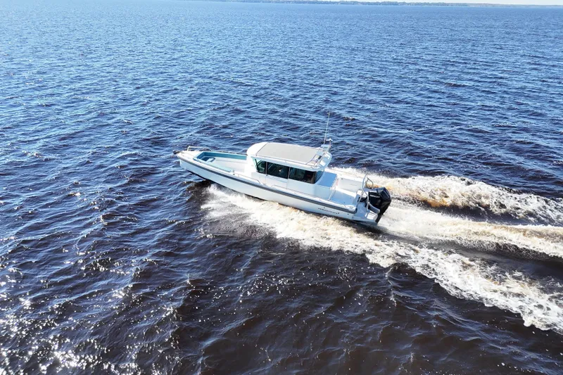 Slide: The Image of 2020 Axopar 28 CABIN boat cruising on open water, aerial view. - 38