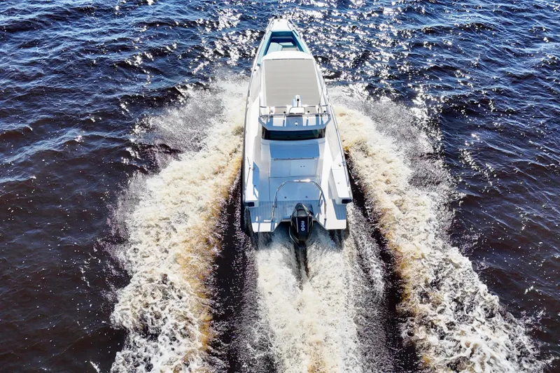 Slide: The Image of Axopar 28 CABIN 2020 boat cruising on open water, aerial rear view. - 41