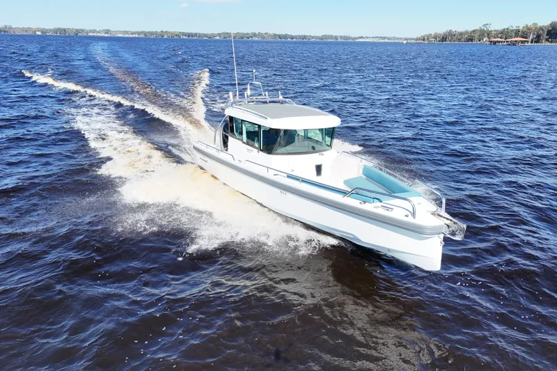 Slide: The Image of 2020 Axopar 28 CABIN A/C cruising on a sunny day in open waters. - 8