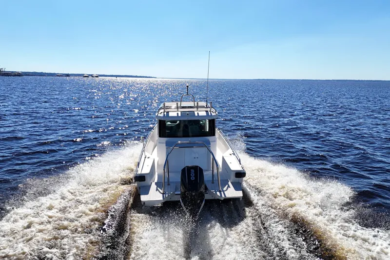 Slide: The Image of 2020 Axopar 28 CABIN A/C cruising on open water under clear blue sky. - 9