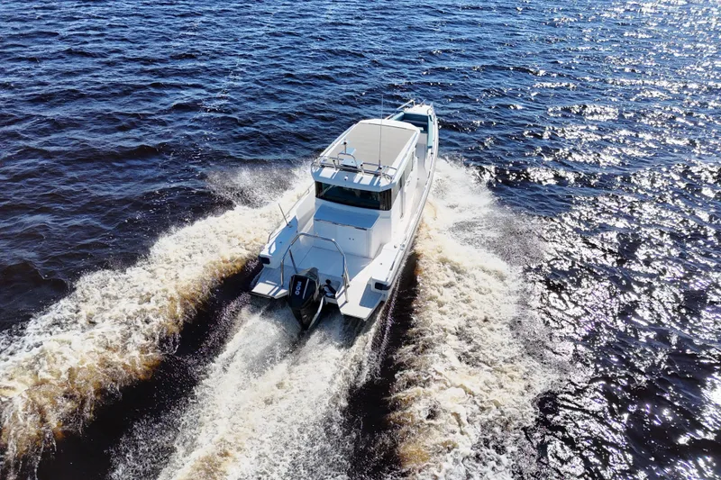 Slide: The Image of 2020 Axopar 28 CABIN boat cruising on open water, creating a wake. - 10