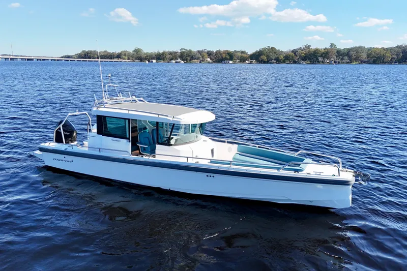 Slide: The Image of 2020 Axopar 28 CABIN boat on calm blue water under a clear sky. - 16