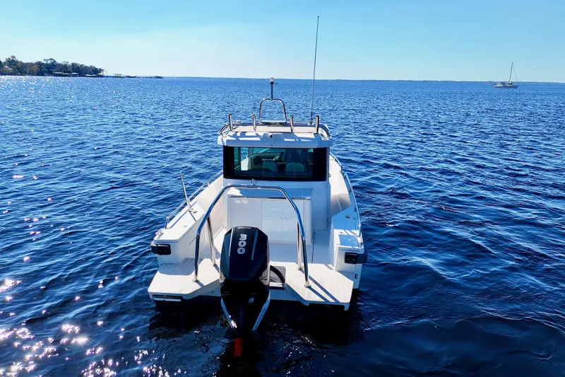 Slide: The Image of Axopar 28 CABIN 2020 boat on calm blue water, rear view. - 26