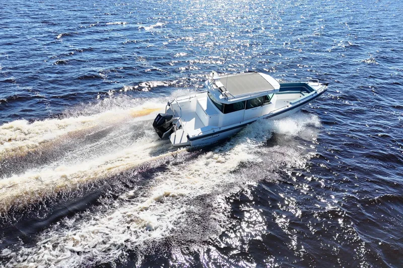 Slide: The Image of 2020 Axopar 28 CABIN A/C cruising on open water, creating a dynamic wake. - 33