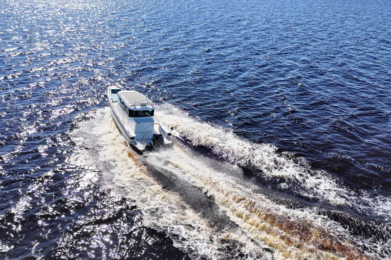 Slide: The Image of 2020 Axopar 28 CABIN A/C cruising on open water, creating a dynamic wake. - 35