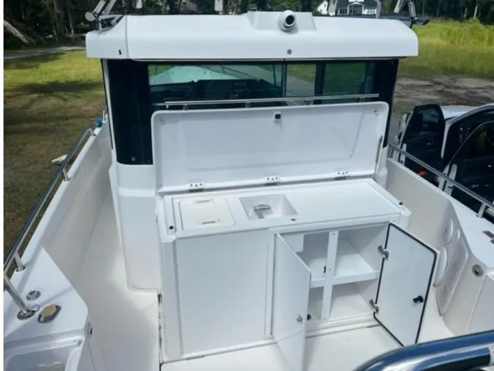 Slide: The Image of 2020 Axopar 28 boat with open storage compartments and sink on deck. - 55