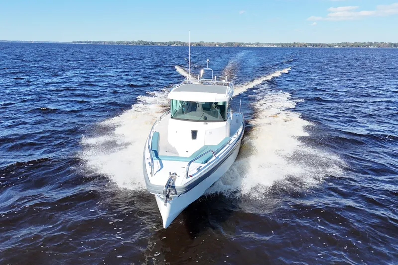 Slide: The Image of 2020 Axopar 28 CABIN A/C cruising on open water, creating a dynamic wake. - 6