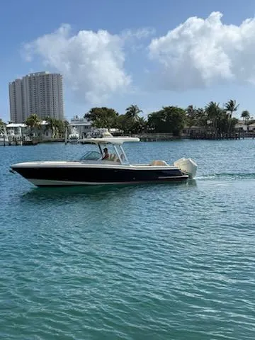 Slide: The Image of 2020 Chris-Craft Calypso 30 boat cruising on a sunny day in a coastal area. - 11