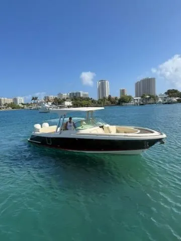Slide: The Image of 2020 Chris-Craft Calypso 30 boat on clear blue water with city skyline in background. - 6