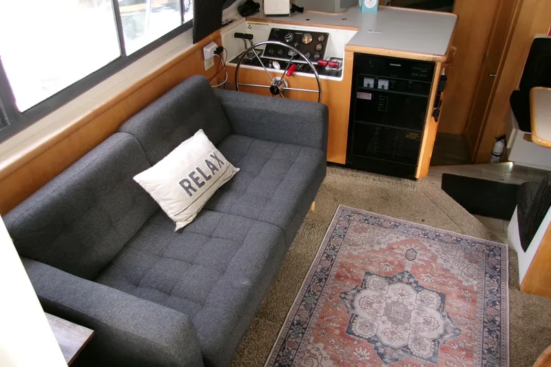 Slide: The Image of Interior of 1995 Carver 355 Aft Cabin Motor Yacht with sofa, pillow, and decorative rug. - 10