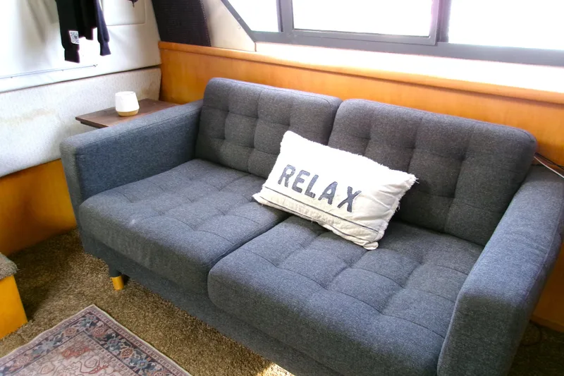 Slide: The Image of Cozy interior of 1995 Carver 355 Aft Cabin Motor Yacht with a plush sofa and "Relax" pillow. - 13