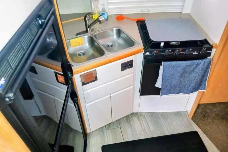 Slide: The Image of 1995 Carver 355 Aft Cabin Motor Yacht kitchen with sink, stove, and refrigerator. - 15