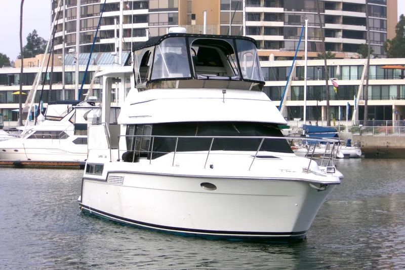 Slide: The Image of 1995 Carver 355 Aft Cabin Motor Yacht docked in marina, surrounded by modern buildings. - 2