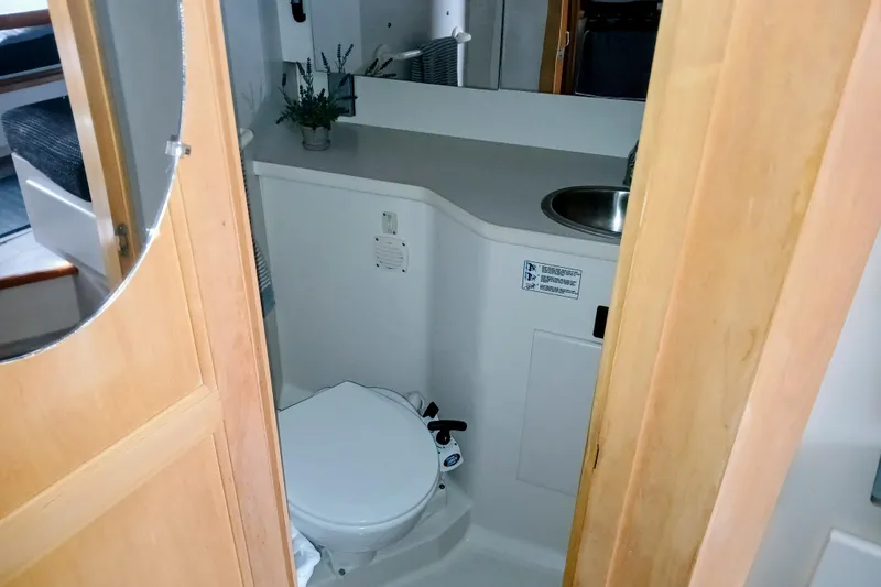 Slide: The Image of 1995 Carver 355 Aft Cabin Motor Yacht bathroom with toilet, sink, and mirror. - 22