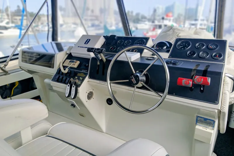 Slide: The Image of 1995 Carver 355 Aft Cabin Motor Yacht helm with steering wheel and control panel. - 24