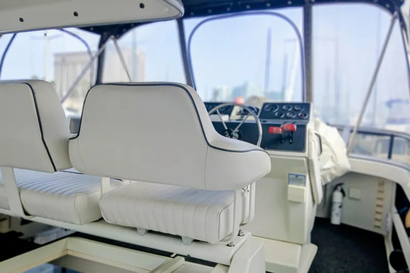 Slide: The Image of Interior of 1995 Carver 355 Aft Cabin Motor Yacht with white seating and control panel. - 25