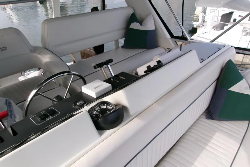 Slide: The Image of 1995 Carver 355 Aft Cabin Motor Yacht helm with white seating and navigation controls. - 27