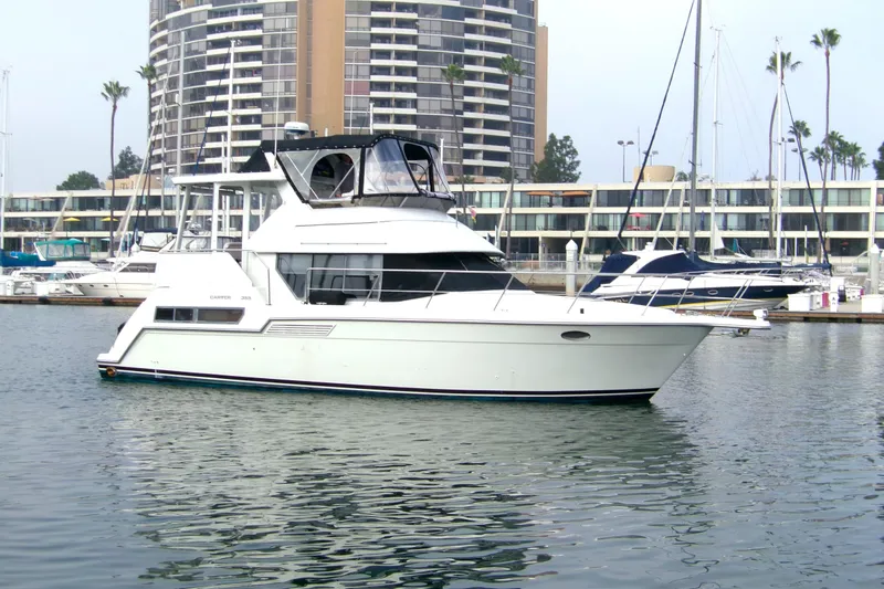 Slide: The Image of 1995 Carver 355 Aft Cabin Motor Yacht docked in marina, with modern buildings in background. - 3