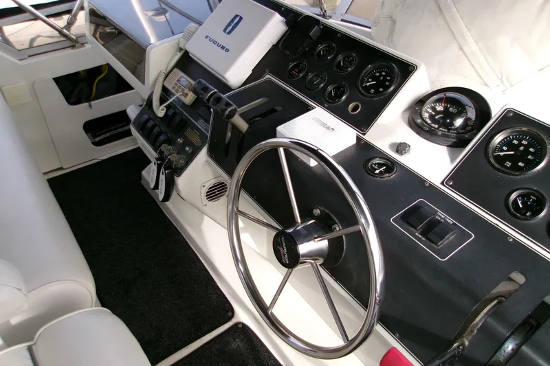 Slide: The Image of 1995 Carver 355 Aft Cabin Motor Yacht helm with steering wheel and navigation instruments. - 30