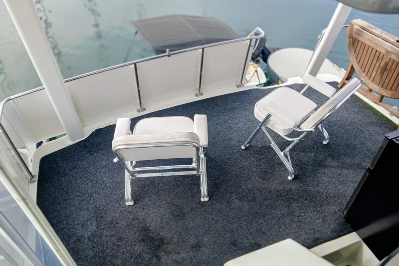 Slide: The Image of 1995 Carver 355 Aft Cabin Motor Yacht deck with chairs, overlooking water. - 6