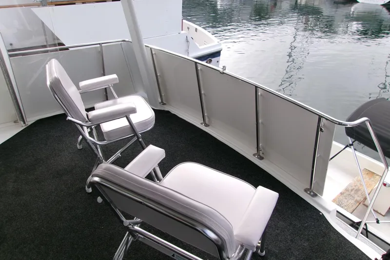 Slide: The Image of 1995 Carver 355 Aft Cabin Motor Yacht deck with chairs overlooking water. - 7