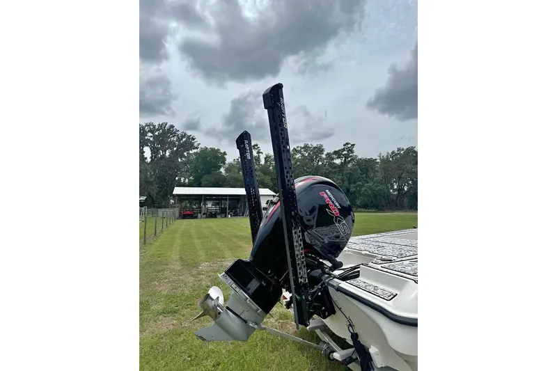 Slide: The Image of 2006 Triton 191 LTS boat with Mercury engine, parked on grassy field. - 4