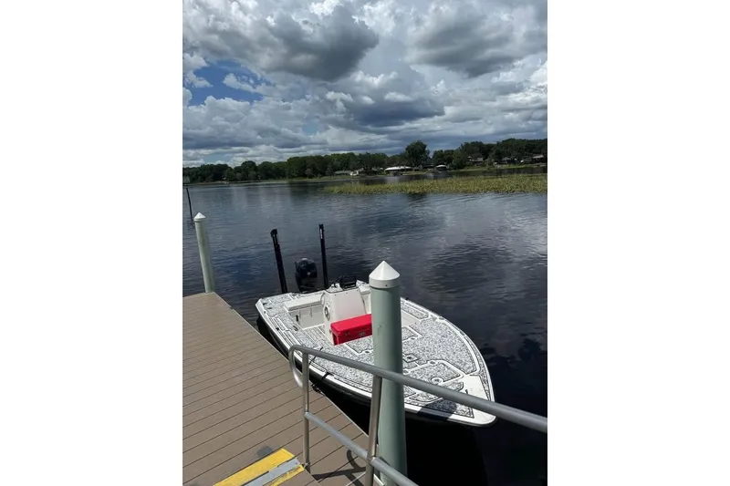 Slide: The Image of 2006 Triton 191 LTS boat docked on a calm lake under cloudy skies. - 6