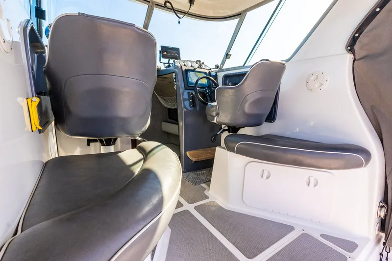 Slide: The Image of Interior of a 2008 Protector 410 Targa boat, featuring modern seats and helm. - 46